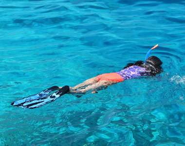 Snorkeling over coral reef in clear turquoise water in Zanzibar 